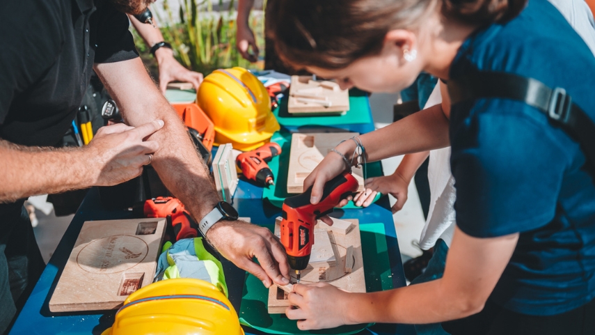 Dziecko buduje statek pod okiem opiekuna