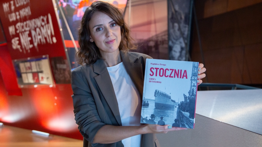 Magdalena Staręga wraz z książką, na okładce statek