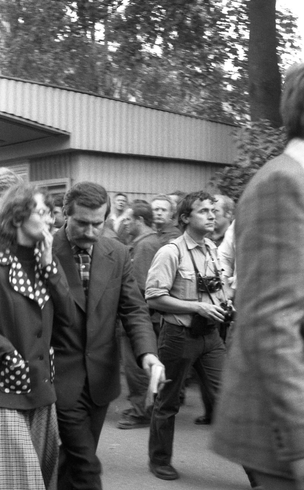 Alina Pienkowska i Lech Wałęsa zmierzają w stronę Bramy nr 2, aby poinformować oczekujących na placu o wynikach negocjacji z delegacją rządową, 29 sierpnia 1980